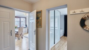 Un couloir comprenant un coin repas, un tableau et un panneau fixé au mur.