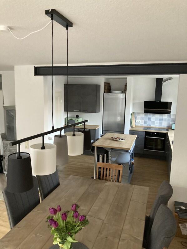 Una cocina moderna con horno empotrado, microondas y refrigerador de acero inoxidable.