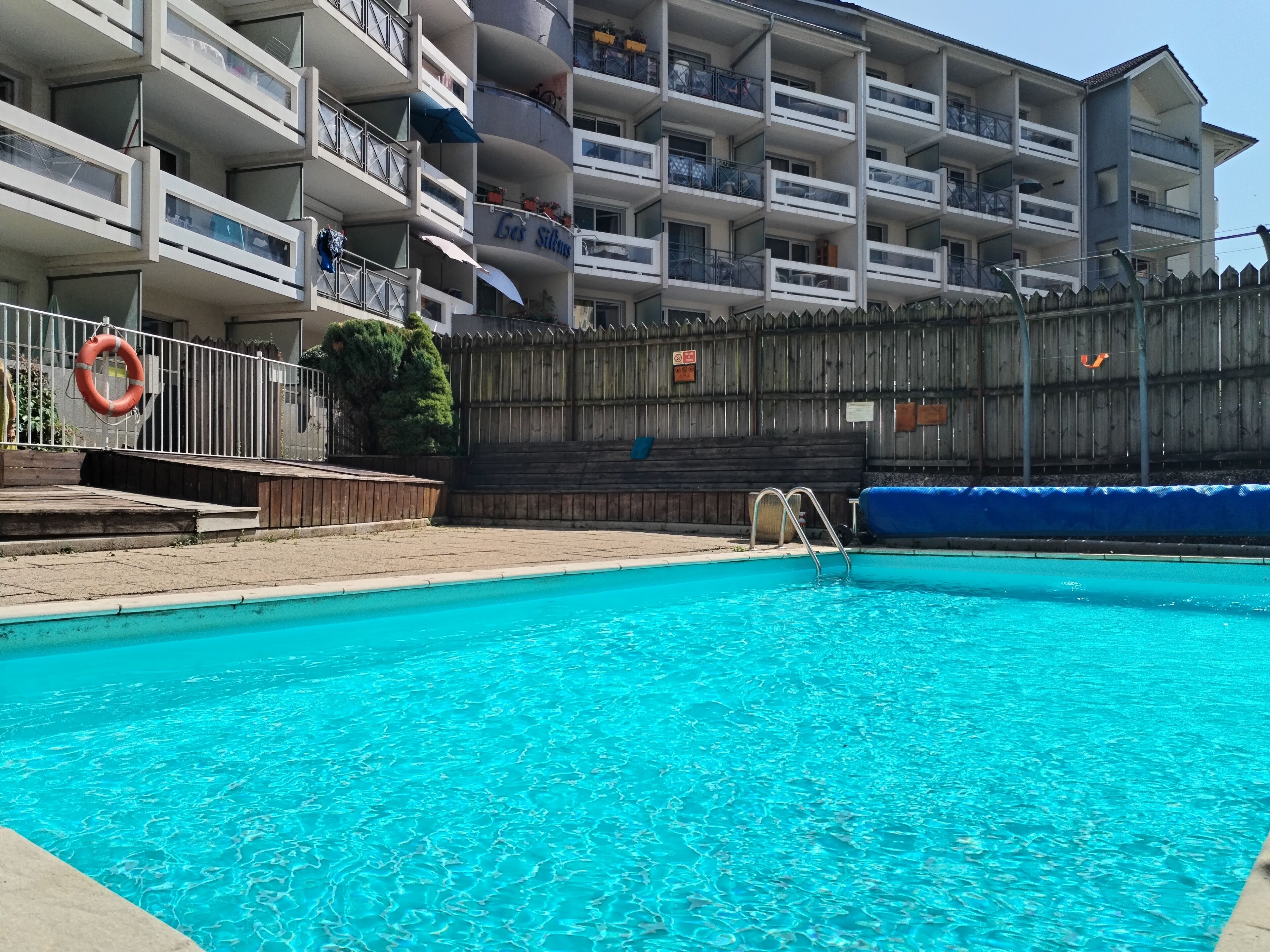 Piscine extérieure en saison, chaises longues