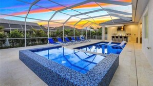 A modern outdoor swimming pool with a glass ceiling, surrounded by lounge chairs and a view of the landscape.