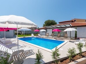 Relax by the pool surrounded by comfortable seating and lush greenery.