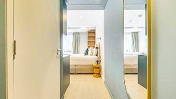 Ett modernt hotellrum med en säng, ett sängbord och en stor spegel.