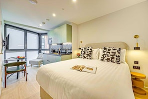 Ein modernes Schlafzimmer mit einem großen Bett, einem Schreibtisch und einem Stuhl.
