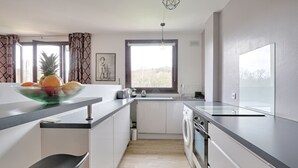 A modern kitchen with a large island, built-in appliances, and a view of the outdoors. - Swingcat - Charmant appt pour 2 (Athis Mons)