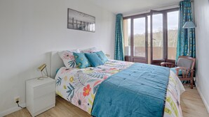 A bedroom with a bed, a nightstand, a chair, and a window with curtains. - Swingcat - Charmant appt pour 2 (Athis Mons)