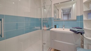 A modern bathroom with a glass-enclosed shower, a white sink, and a mirror above it. - Swingcat - Charmant appt pour 2 (Athis Mons)