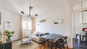 Un espacio habitable pequeño con una mesa de comedor, sofá y una kitchenette.
