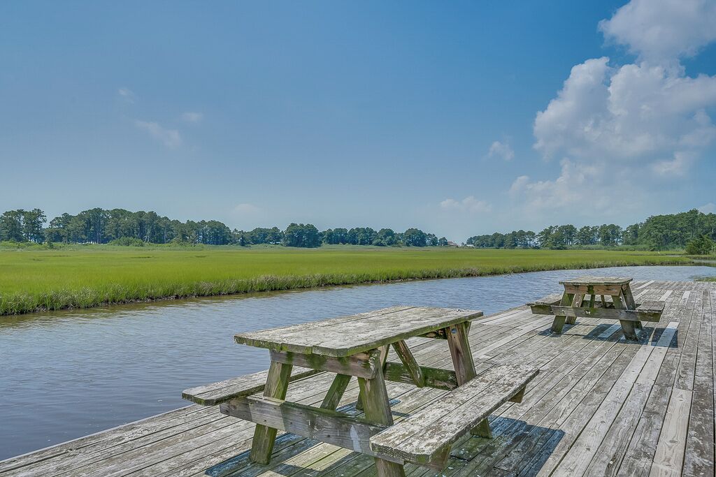 Eine Holzsteganlage mit Picknicktischen mit Blick auf einen Fluss.