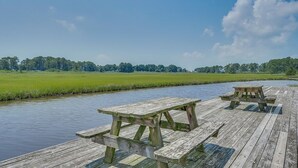 Une jetée en bois avec des tables de pique-nique, donnant sur une rivière.