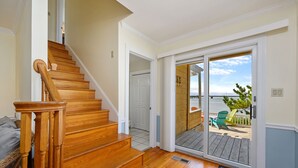 Una escalera de madera que conduce a un gran ventanal corredizo.