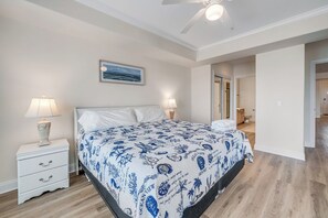 Ein Schlafzimmer mit Bett, Nachttischen, Deckenventilator und einem Bild an der Wand.