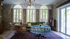 A room with a green sofa, a round table with a blue tablecloth, and a chandelier. - Stunning private villa for 11 people with private pool, A/C, WIFI, TV and patio (Draguignan)