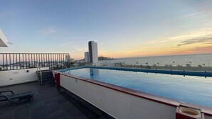 A rooftop pool with a view of the ocean and cityscape at sunset. - Depas VAL704 By Trvl2hm Mazatlan Regency (Mazatlán)