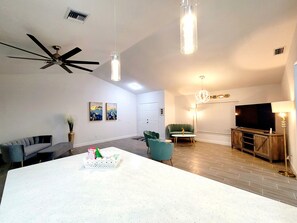 Relax in this stylish living space with a central island, comfortable seating, and a large flat-screen TV.