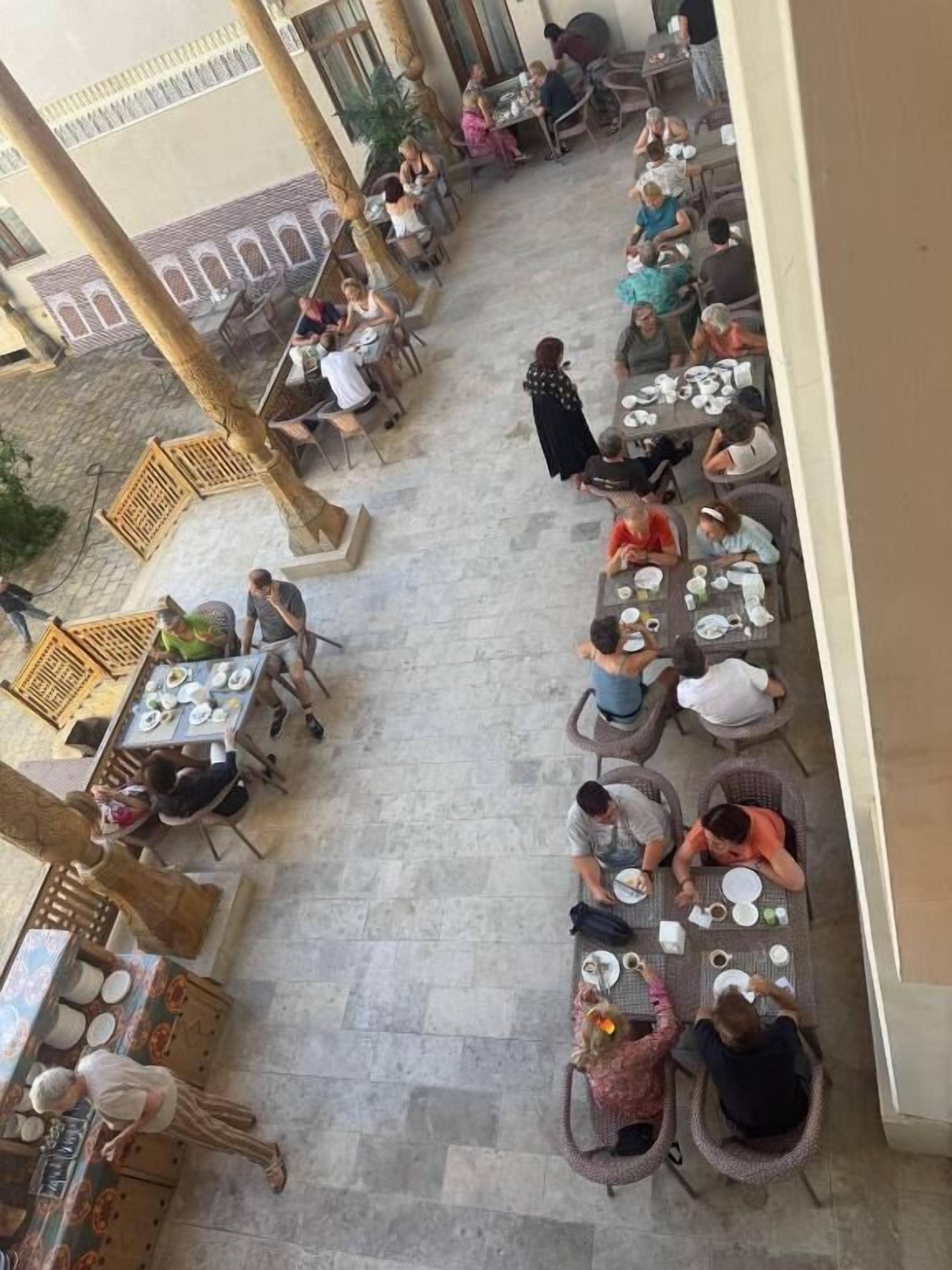 Un café en plein air avec des tables et des chaises disposées pour accueillir les clients.