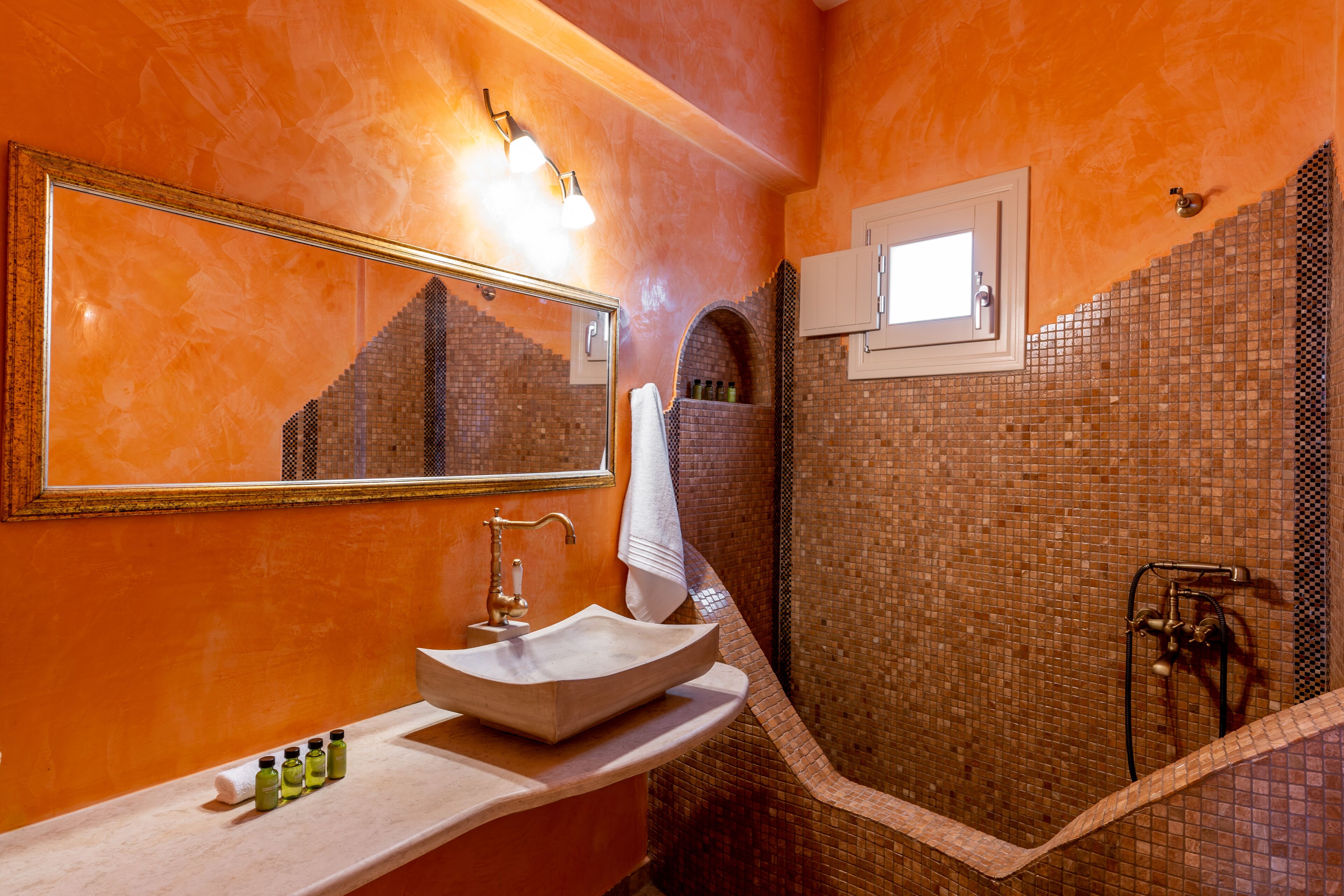 A bathroom with a large mirror, a sink, and a shower area.