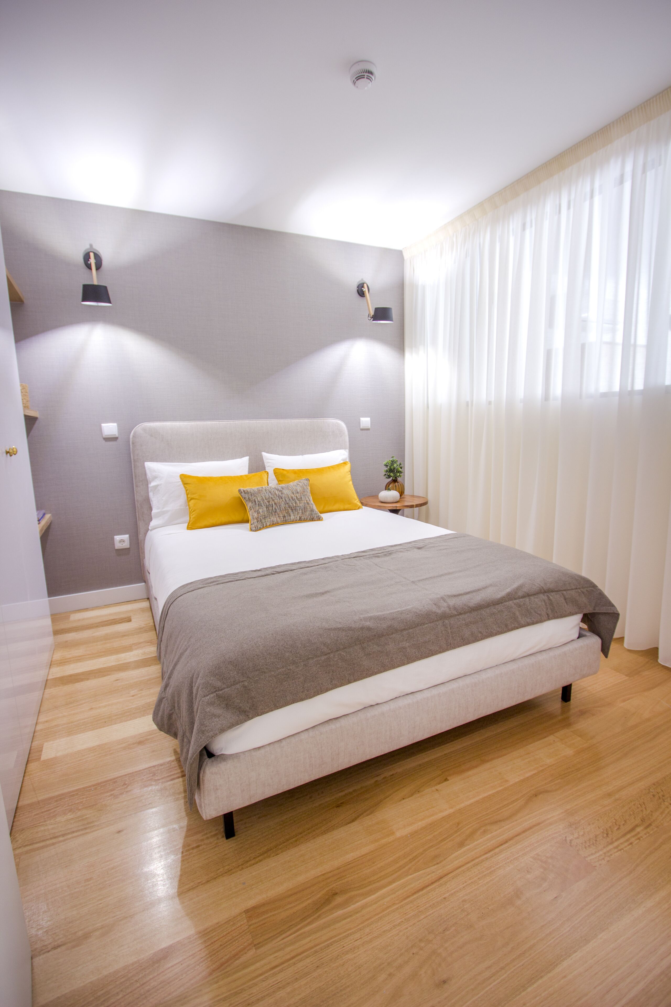 Un dormitorio moderno con una cama grande, una mesita de noche y una lámpara de noche.