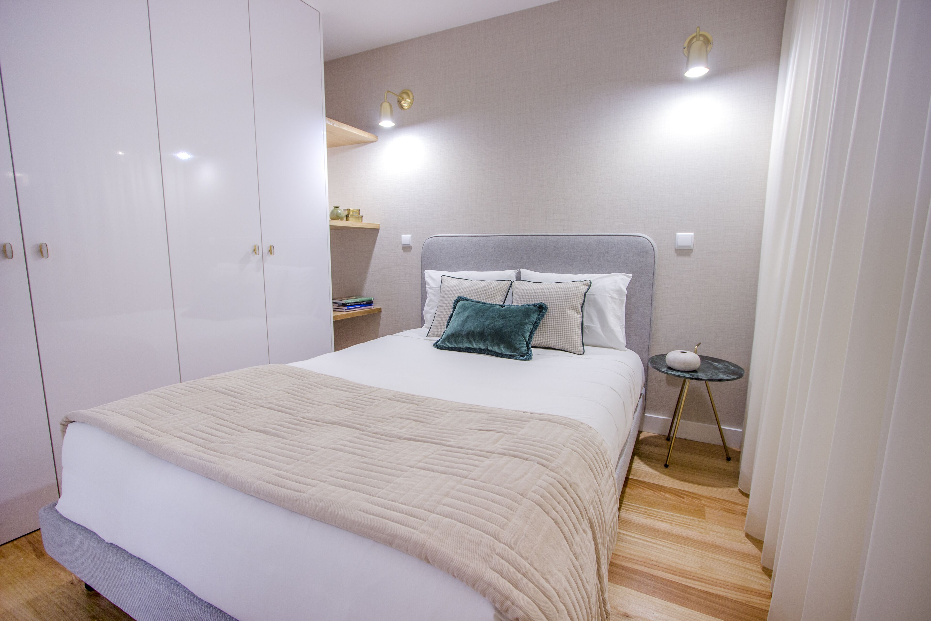Une chambre bien rangée, avec un lit, une table de chevet et une armoire.