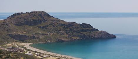 A coastal town with a prominent hill, a beach, and a marina.