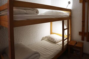A bunk bed with a wooden frame, two pillows, and a small wooden table beside it. - Ski-in/ski-out & foot of the slopes, 5th floor, view valley, balcony, tv, 21m², Les Orres (Les Orres)