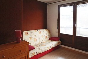 A room with a sofa, a wooden dresser, and a window. - Ski-in/ski-out & foot of the slopes, 5th floor, view valley, balcony, tv, 21m², Les Orres (Les Orres)