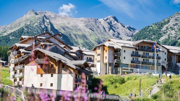 A mountain resort with wooden buildings and a view of the mountains.