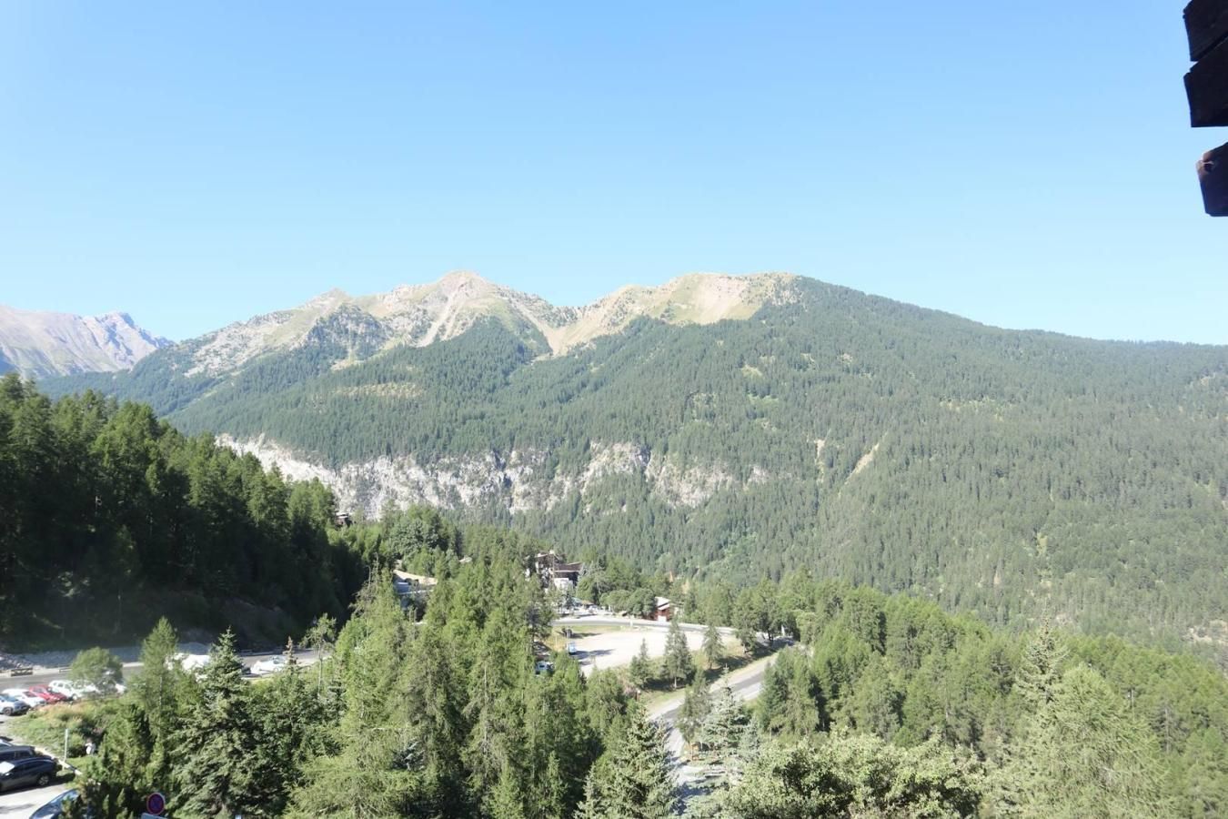 A mountainous landscape with a small settlement and forested area.