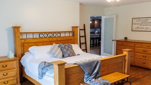 Una cama de madera con cabecera, una mesita de noche y un banco.
