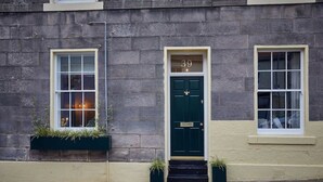 A building with a dark green door marked with the number 39, two windows with white frames, and a small entrance with steps. - The Jungle Nook: Romantic Hideaway with Log Burner (Berwick-upon-Tweed)