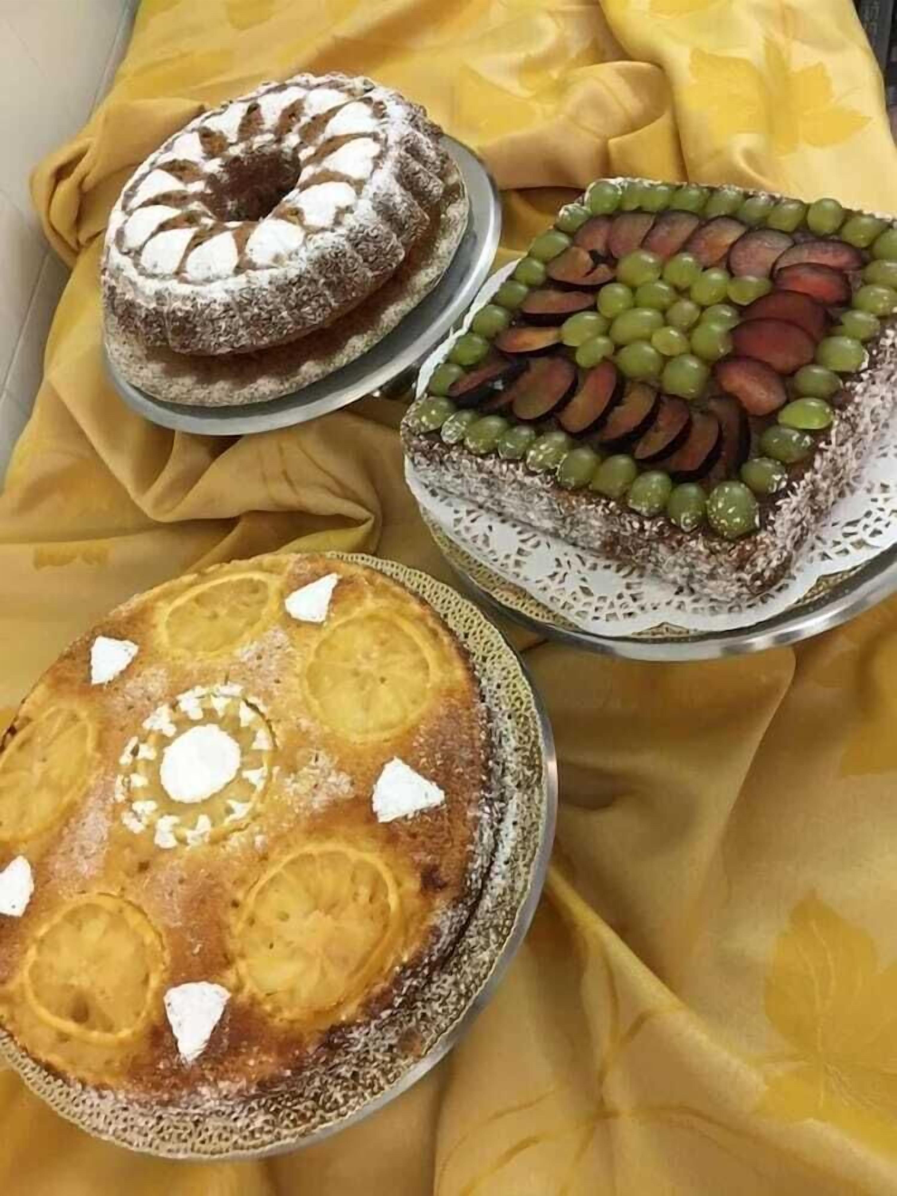 Drie taarten op een tafel met een gele doek.