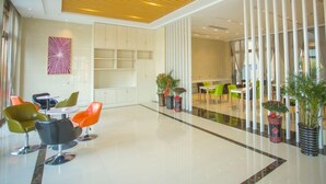 A modern lobby with a high ceiling, a central seating area with colorful chairs, and potted plants. - Greentree Inn Hefei Lujiang County No.1 Jin Street Express Hotel (Hefei)