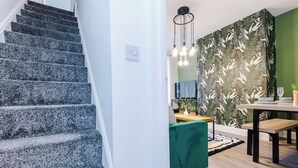 Eine Treppe führt zu einem Essbereich mit einer grünen Sitzbank und einem Tisch.