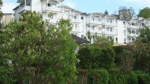 A multi-story hotel with balconies and a lush green landscape in the foreground. - Close to the beach and with sea views, apartment in a quiet, central location (Göhren)