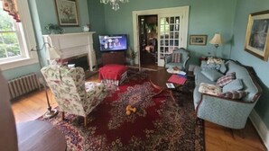 A cozy living room with a fireplace, a television, and comfortable seating. - Harriet's Highlands Hideaway (Mount Pleasant)