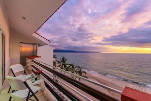 A balcony with a view of the ocean at sunset. - WIVC Casa de la Playa Condo - Literally on the Beach with Swimming Pool & Jacuzzi (Puerto Vallarta)