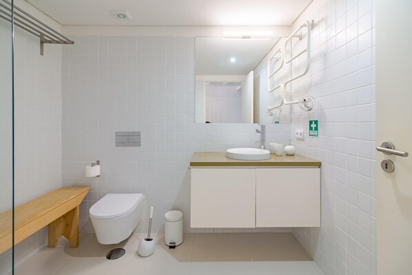 A modern bathroom with a toilet, sink, and mirror. - Porto Vitoria 5 in Oporto (Porto)
