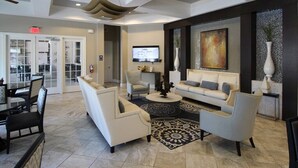A modern lobby with a sofa set, a coffee table, and a TV mounted on the wall. - ⛱ Solterra Resort - 5★ Clubhouse - Champions Gate Area - Extended Pool & Deck ✈ (Davenport)