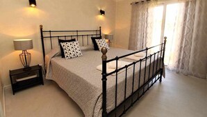 Une chambre à coucher avec un lit à baldaquin, des lampes de chevet, une table de chevet et une fenêtre avec des rideaux.