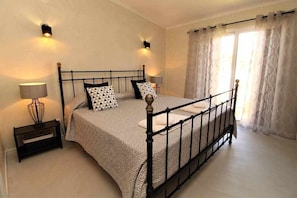 Une chambre à coucher avec un lit à baldaquin, des lampes de chevet, une table de chevet et une fenêtre avec des rideaux.