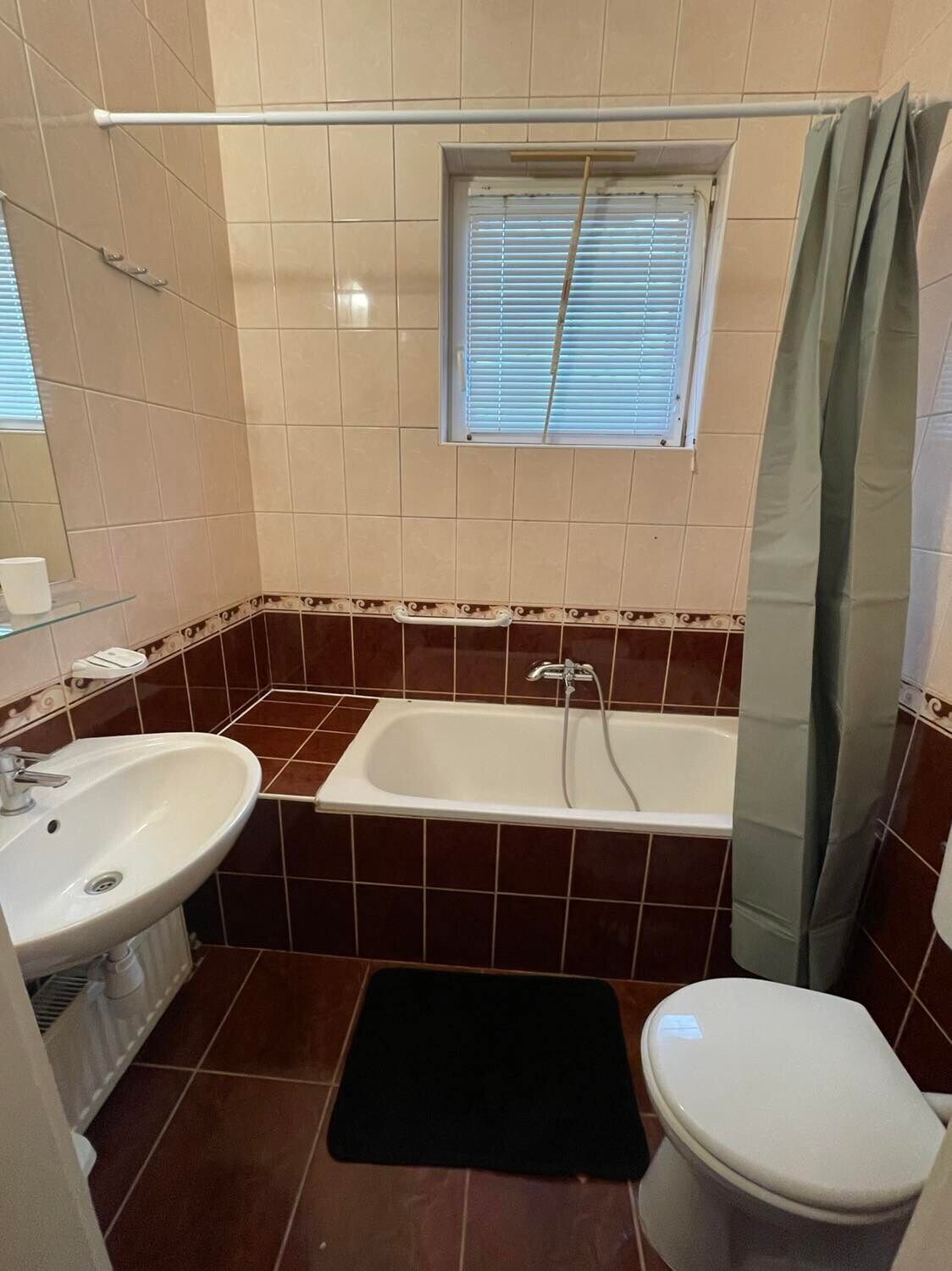 Un baño con bañera, lavamanos e inodoro.