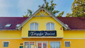 A yellow building with a sign reading "Tölgyúbánzi Panzió". - Tölgyfa Panzió (Miskolc)