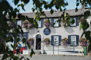 A building with a sign for 'MADELINES Accommodation' and flower boxes on the windows. - Madelines Accommodation (Tinahely)