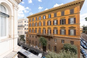 A multi-story building with a classical architectural style, featuring a central balcony and uniform window design. - Ludovisi Apartment near the Spanish Steps and the Trevi Fountain (Rome)