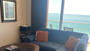 Un salon moderne avec un canapé bleu, une table basse en bois et un tableau encadré accroché au mur.