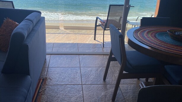 Une pièce avec vue sur l’océan, un canapé, un fauteuil et une table.