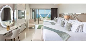 Ein Hotelzimmer mit zwei Betten, einem Schreibtisch mit Stuhl, einem großen Spiegel und Meerblick.