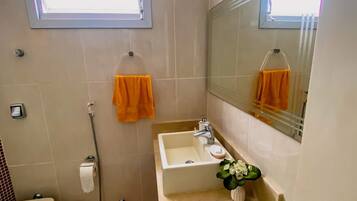 A bathroom with a toilet, sink, and shower.