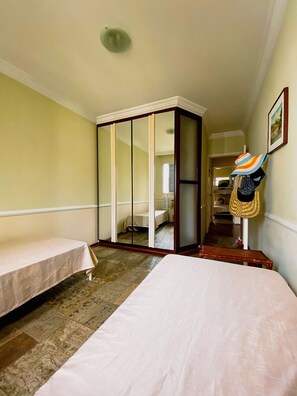 A hotel room with two single beds, a large mirror, a cat tree, and a framed picture on the wall. - Duplex 500 metros da Praia - Guarujá (Guarujá)