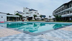 Una piscina con suelo de baldosas, rodeada de edificios de varios pisos y balcones.