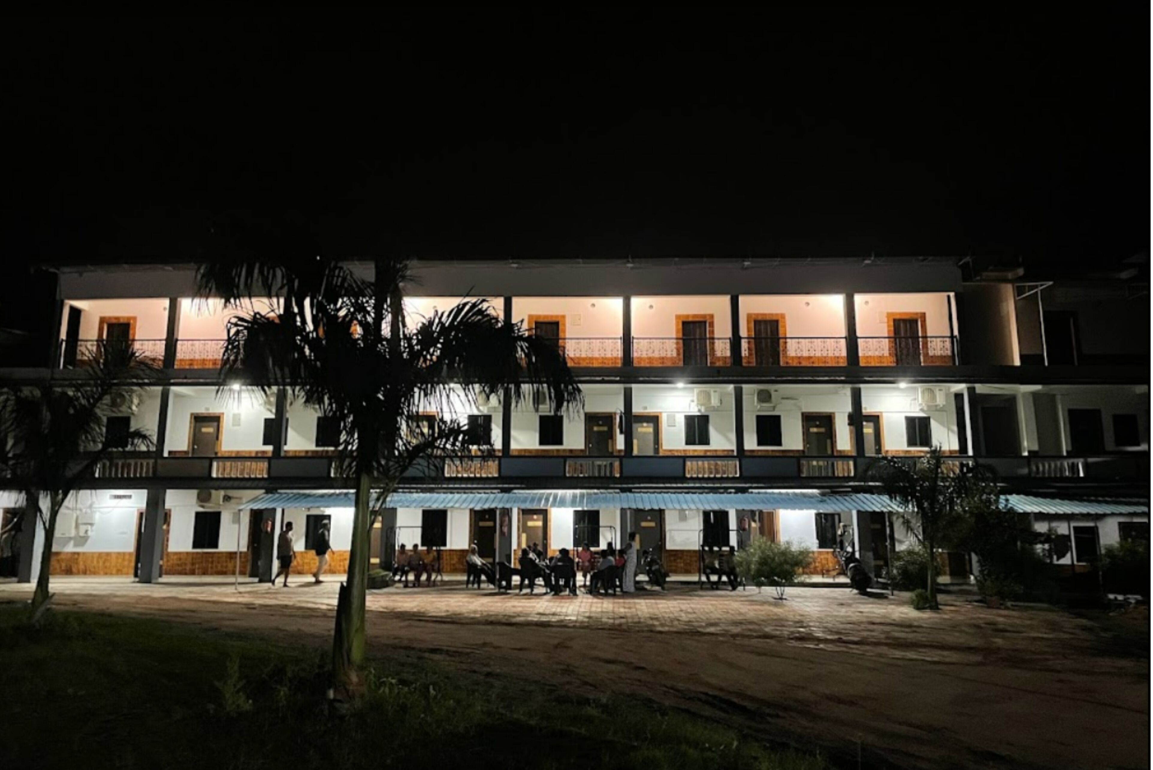 A multi-story building with a covered front area and a balcony.